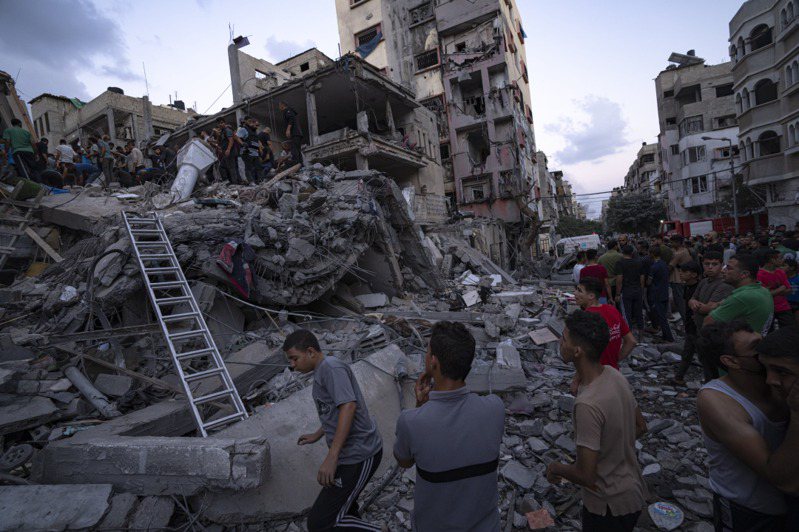 以色列反擊哈瑪斯，對加薩走廊大規模空襲。圖為巴勒斯坦人10日在一棟被摧毀的建築廢墟中尋找傷者。（美聯社）