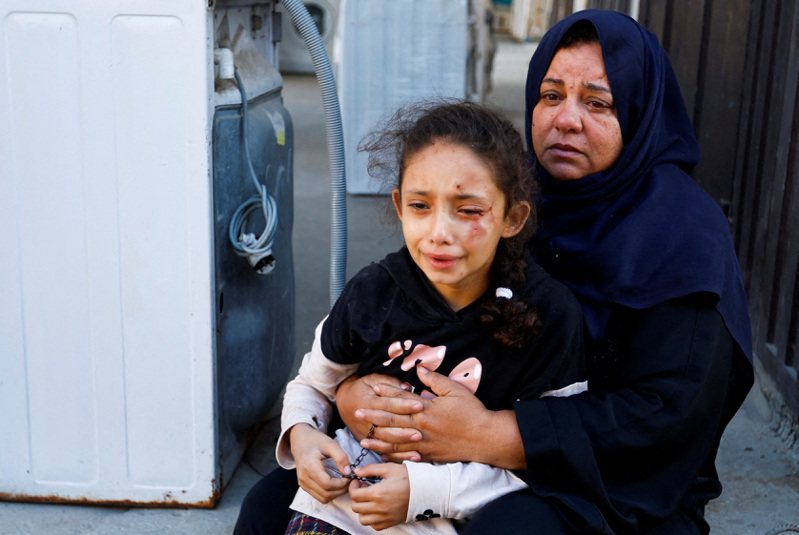 加薩一名巴勒斯坦女孩12日因以色列空襲受傷落淚。路透