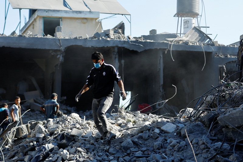 以巴衝突持續，圖為巴勒斯坦的人員在廢墟內找尋傷亡民眾。路透社