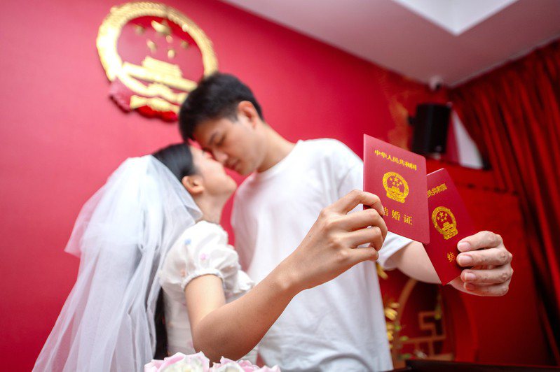 據統計，中國2022年結婚人數跌破700萬對大關，是連續第9年下降。分析認為，這和適婚人數減少、思想觀念變化、疫情影響等因素有關。圖為一對新人在民政局婚姻登記處領取結婚證。新華社