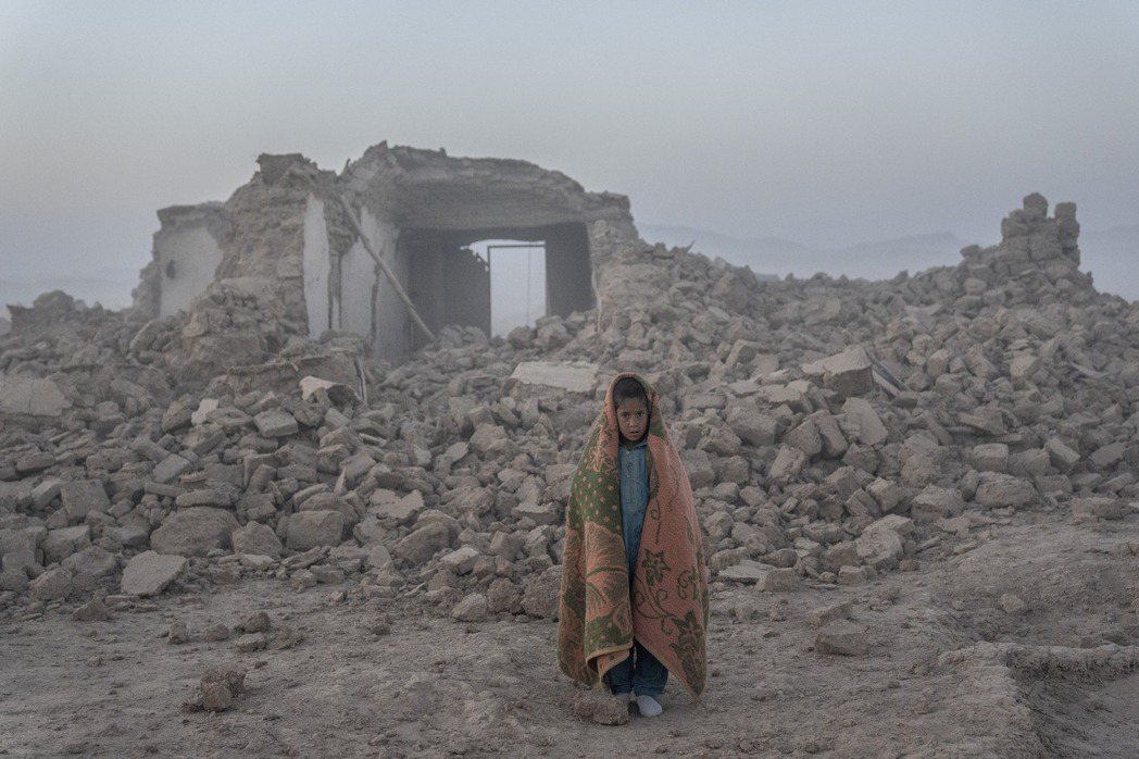 10月11日，阿富汗西部赫拉特省繼10月7日後再度發生強震，圖為一名男孩站在他的...