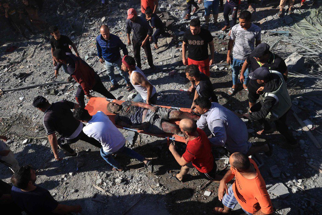 2023年10月16日，以色列對拉法發動空襲後，一名巴勒斯坦青年被從建築物廢墟下...