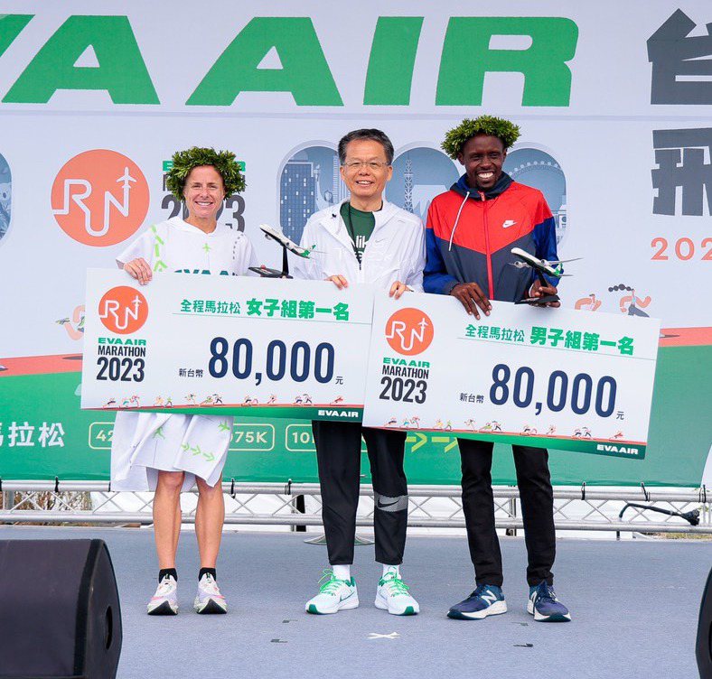 長榮航空總經理孫嘉明（中）將獎金及飛機模型頒給全程馬拉松男、女組冠軍肯亞的David及澳洲的Fien。圖／長榮提供