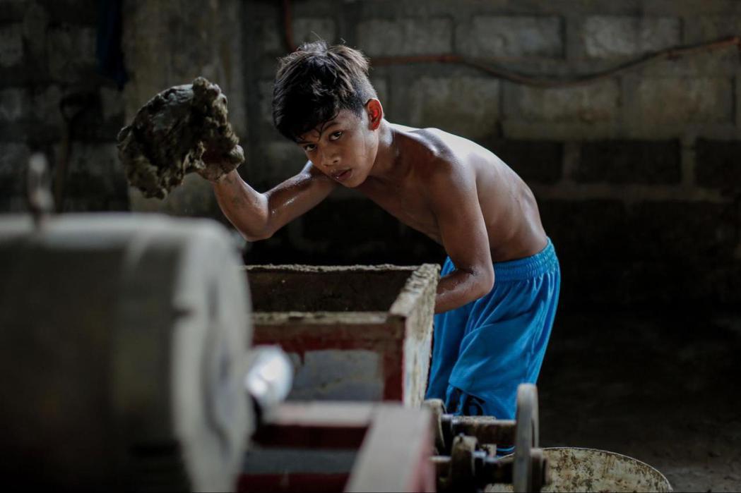 菲律賓潘帕嘉省聖托馬斯陶器工廠的童工。 圖／歐新社　