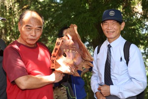 羅明原（右）花了16年時間爬完了台灣除了軍區以外的三等以上的三角點，一共1176顆，山友送他台灣第一人的木雕。記者邱德祥／攝影