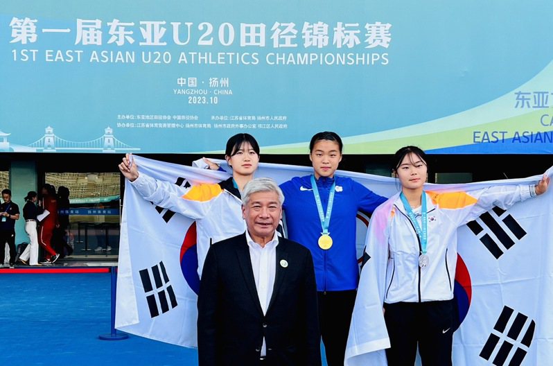 中華田徑協會祕書長王景成（前）為女子100公尺奪金的黃郁庭頒獎。圖／中華田徑協會提供