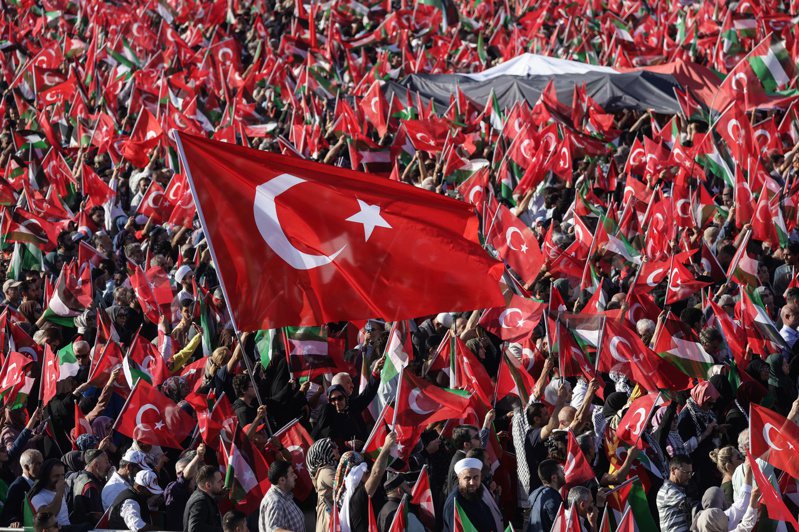 在以色列與巴勒斯坦加薩地區哈瑪斯武裝份子間衝突升級的陰影下，土耳其今天低調舉行建國百年慶祝活動，總統厄多安將趁機宣揚他的執政成果。圖為土耳其總統厄多安的支持者在土耳其伊斯坦堡阿塔圖爾克機場舉行親巴勒斯坦集會期間，舉著土耳其和巴勒斯坦國旗。歐新社