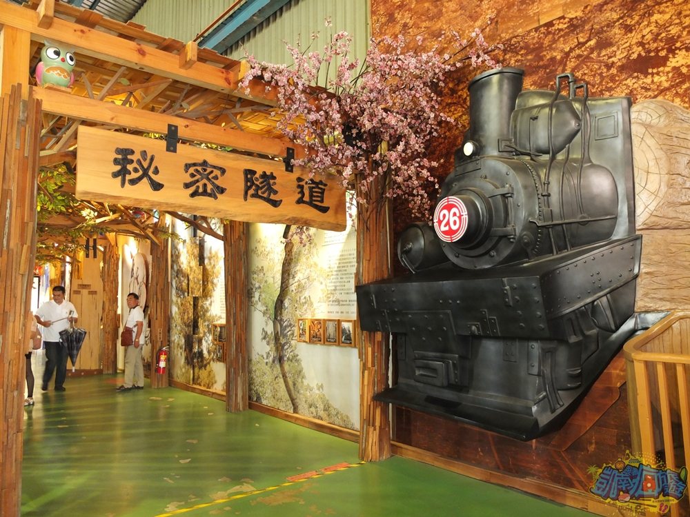 ▲通往館內的「秘密隧道」旁有個載著木材的火車頭裝置藝術造景。