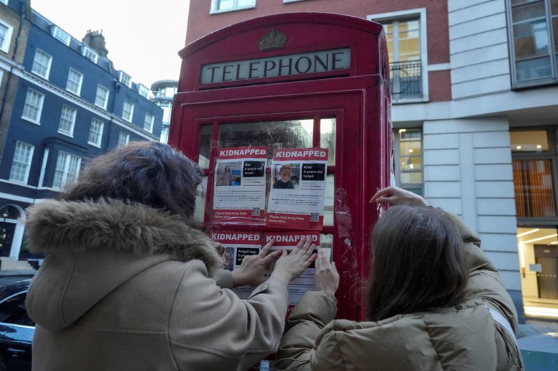 圖為英國倫敦一社區，民眾在卡達大使館附近的電話亭貼上遭綁架的以色列人的傳單。路透社