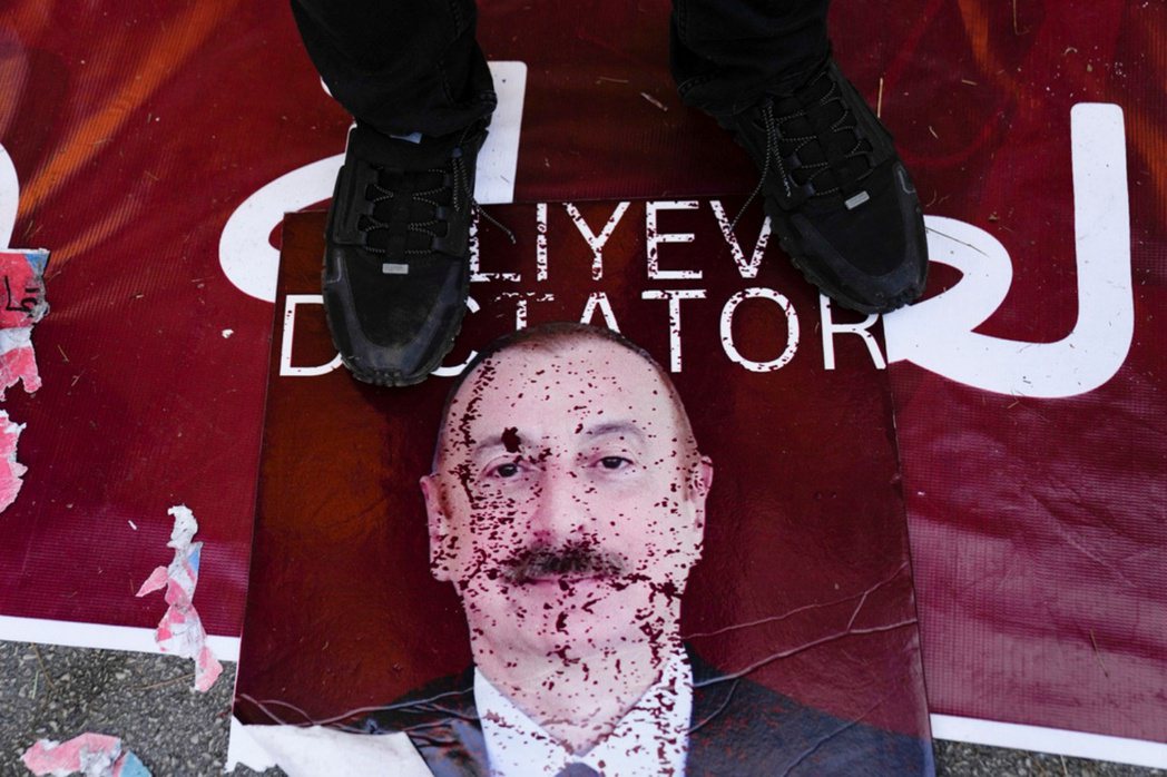 示威抗議者採在亞塞拜然總統阿利耶夫的海報上。 圖／美聯社　