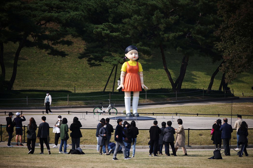 韓劇《魷魚遊戲》的道具娃娃在首爾奧林匹克公園展示，吸引許多劇迷朝聖。 圖／路透社