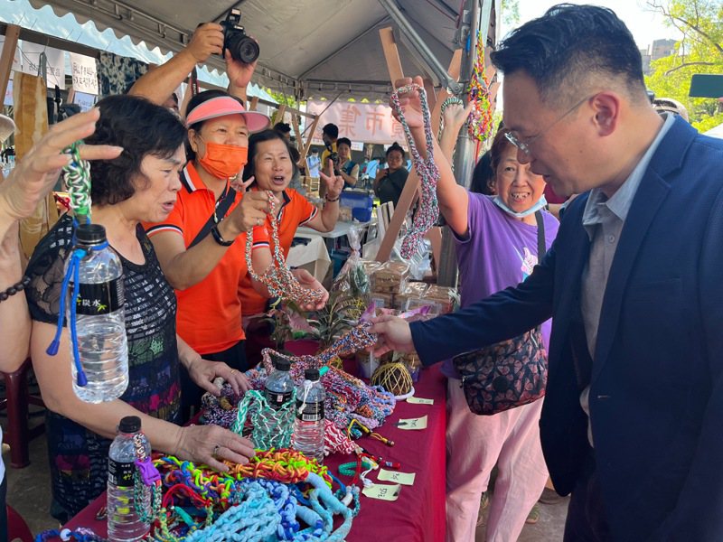 桃園市副市長蘇俊賓（右）被色彩繽紛鮮豔的手作提袋吸引，走上前仔細端詳，詢問製作方式。記者陳俊智／攝影