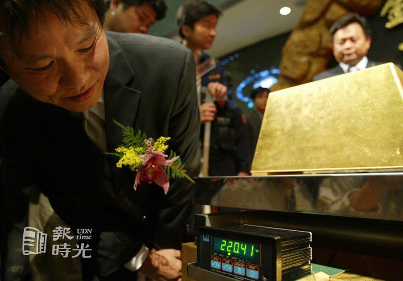 金氏紀錄中心認證時，台北縣代理縣長林錫耀拿起小金磚，與世界最大金磚比一比。聯合報系資料照（2004/11/05 楊克華攝影）