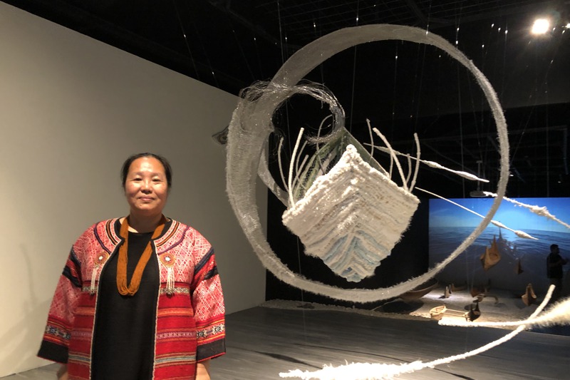 尤瑪．達陸以泰雅紡織獲文化部指定「重要傳統藝術保存者」，成為歷來最年輕的「人間國寶」。圖為她與最新藝術創作「海．揚」、「河．流」的合影。記者何定照／攝影