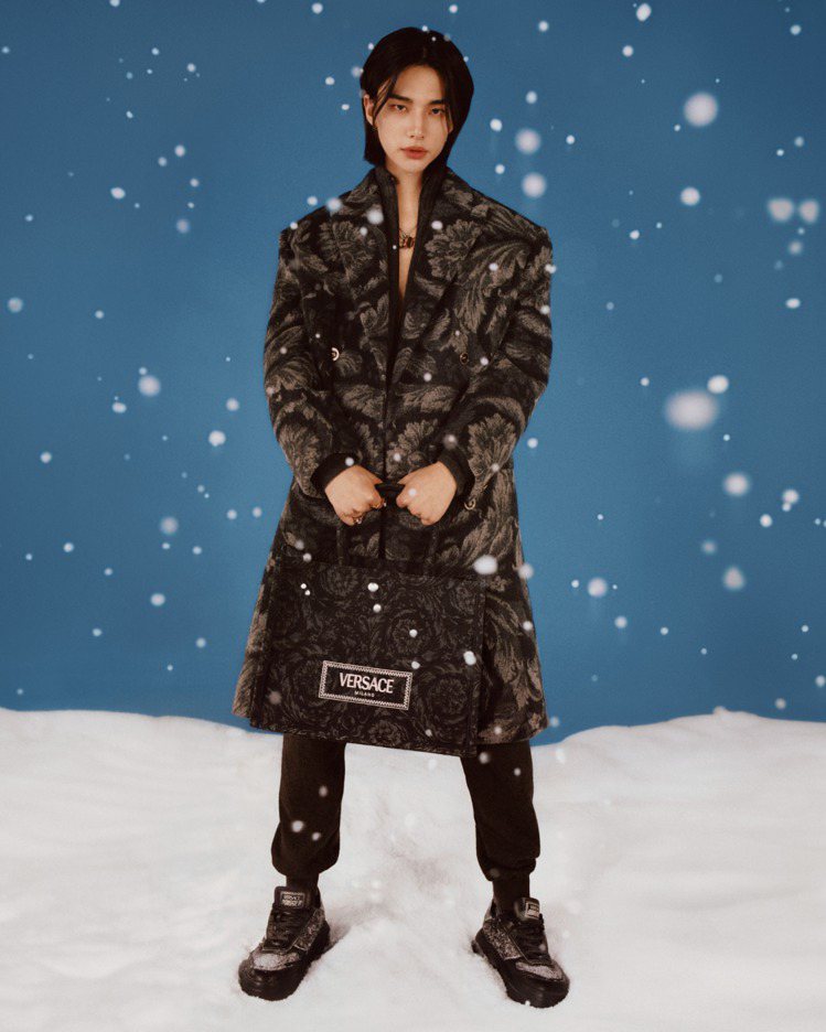 Versace 2023假日系列廣告大片中，黃鉉辰身著Barocco緹花羊絨大衣，搭配羊絨運動褲、Barocco緹花Odissea運動鞋以及Athena托特包。圖／Versace提供