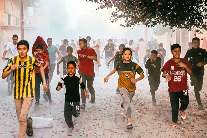 在加薩走廊南部的拉法，一群巴勒斯坦孩童六日奔跑躲避以色列轟炸。（法新社）