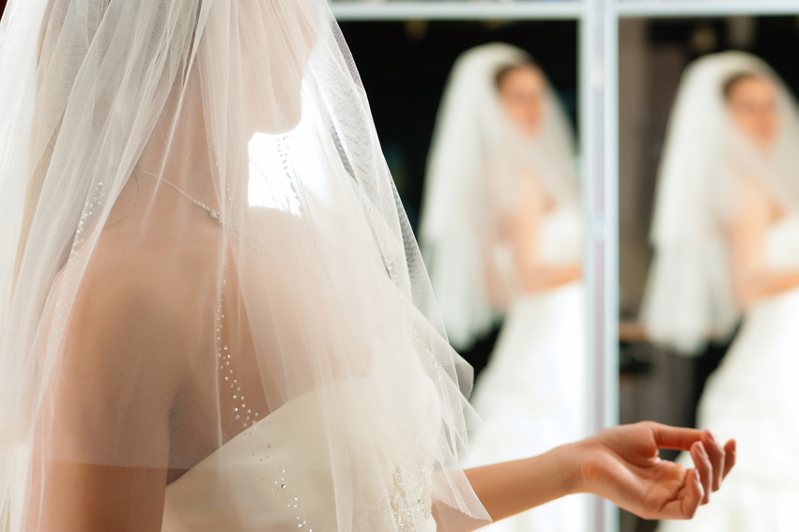 一名英國新娘試穿婚紗時，意外拍到一張詭異的照片，畫面中兩面鏡子所呈現的倒影，與她實際上擺拍的動作有所不同。情境示意圖。圖／Ingimage