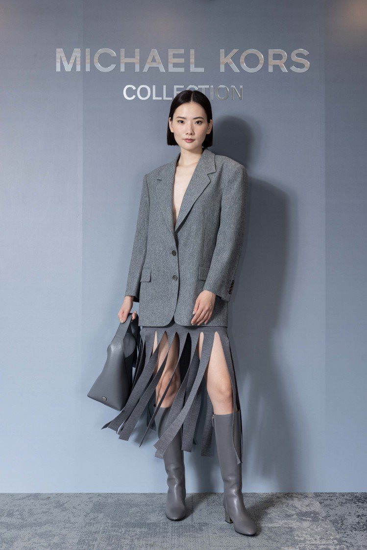 模特兒示範Michael Kors Collection系列灰色羊毛寬版外套70,100元與流蘇裙41,300元。圖／Michael Kors提供