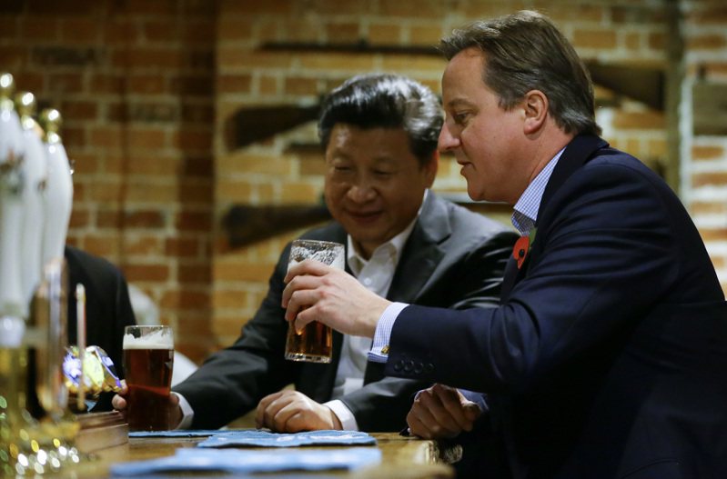 2015年時任英相的卡麥隆邀請訪問英國的習近平一起去喝啤酒。美聯社
