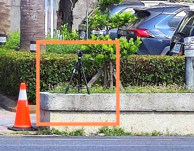 屏東縣恆春警分局不定時在分局前樹叢邊放置錄影三腳架，取締未禮讓斑馬線上行人通行的車輛。圖／民眾提供