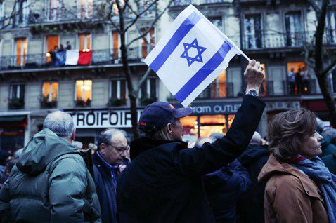 2023年11月12日，法國巴黎一名婦女在抵制反猶主義的遊行中揮舞著以色列國旗。...