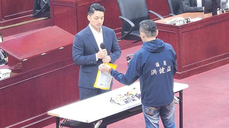 台北市議員洪健益拿出正版與仿冒的走私螺獅粉，要台北市長蔣萬安辨識真偽。記者楊正海／攝影