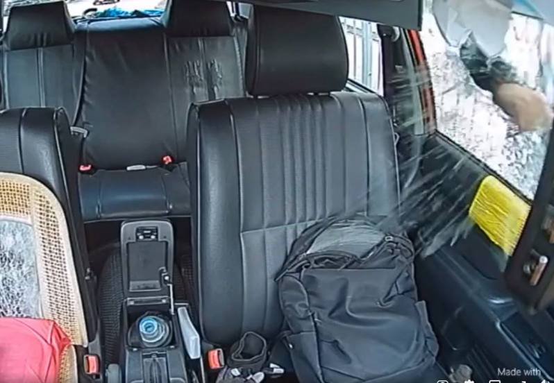 黑衫男於5秒內打破車窗，偷走座椅上的背嚢。（fb群組「的士司機資訊網 Taxi」網上影片截圖」）
