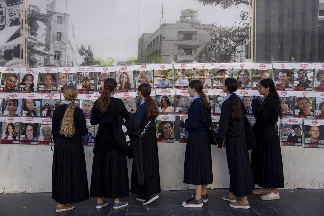 耶路撒冷街頭張貼著據信被綁至加薩的人質相片，民眾3日佇足檢視。美聯社