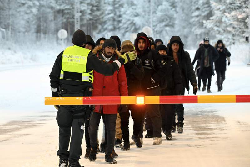 芬蘭邊界警察對難民說明申請庇護注意事項，難民多數被俄國送往芬蘭。法新社