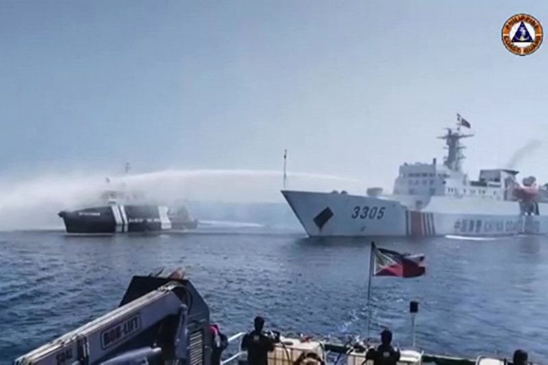 近距離「直擊」 三艘菲律賓船艦昨天（九日）進入大陸實控的黃岩島附近海域，遭到大陸海警船（右）用水砲攻擊。（法新社）