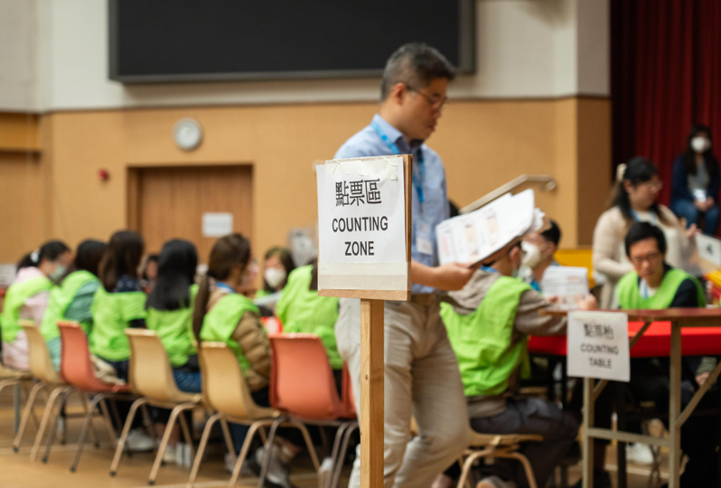 圖為香港第七屆區議會一般選舉投票結束後，11日凌晨1時許，銅鑼灣皇仁書院點票站工作人員正在進行點票工作。（中新社）