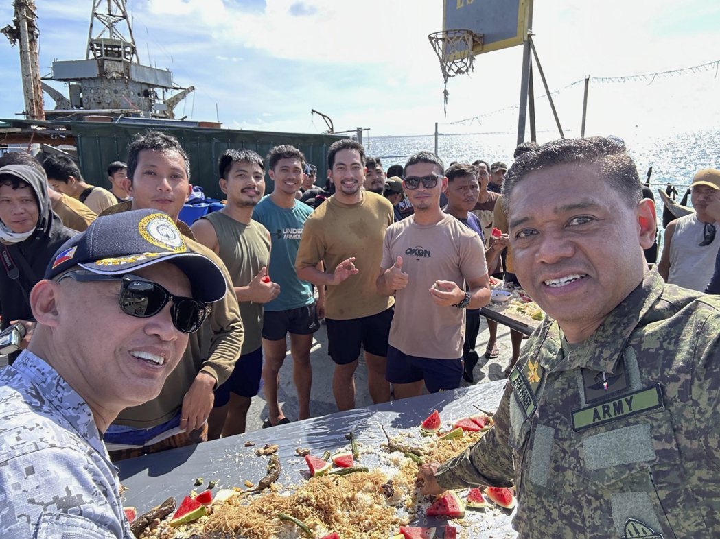 菲律賓軍方高層登上仁愛礁上的「馬德雷山」號廢艦後與艦上成員合影。圖右為菲律賓軍事...