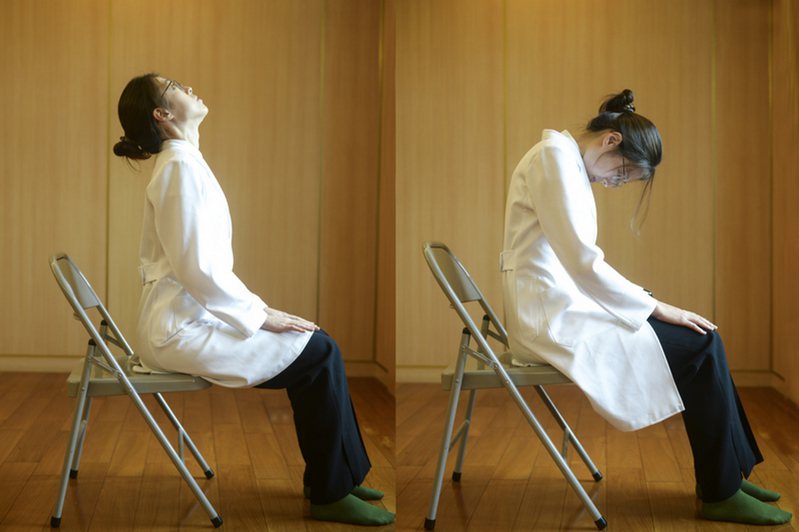 1.貓牛式：坐在椅子前三分之一處，雙手輕放在膝蓋。吸氣時，肩膀向後張，脊椎向上延伸；吐氣時，背部向後拱起，腹部內收。 圖／台北慈濟醫院提供