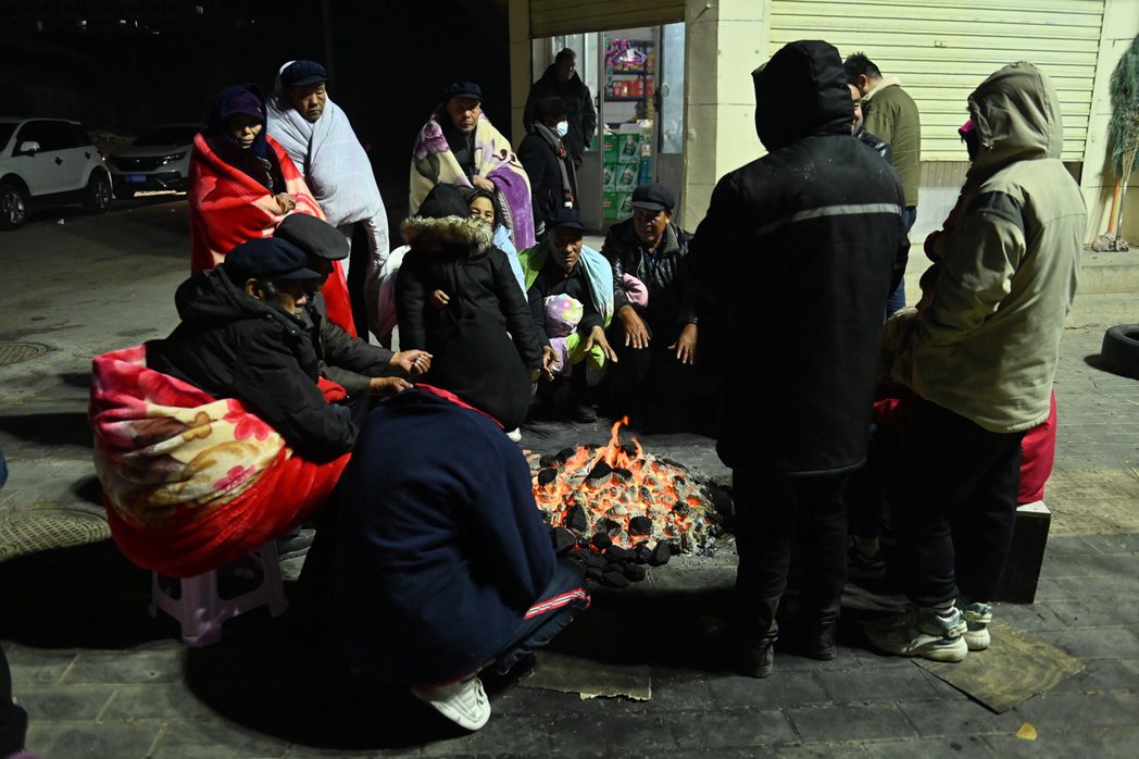 中國甘肅地區近日夜晚氣溫可低至零下15度，從家中逃出的老年人只能裹著棉被、圍在炭...