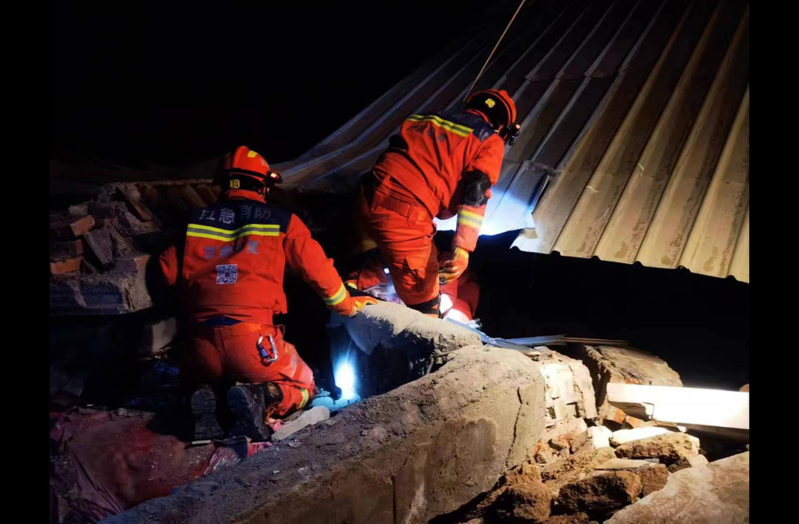 圖為甘肅積石山地震發生後，當地救援人員對兩名受困在倒塌房屋內的民眾展開救援。（新華社）