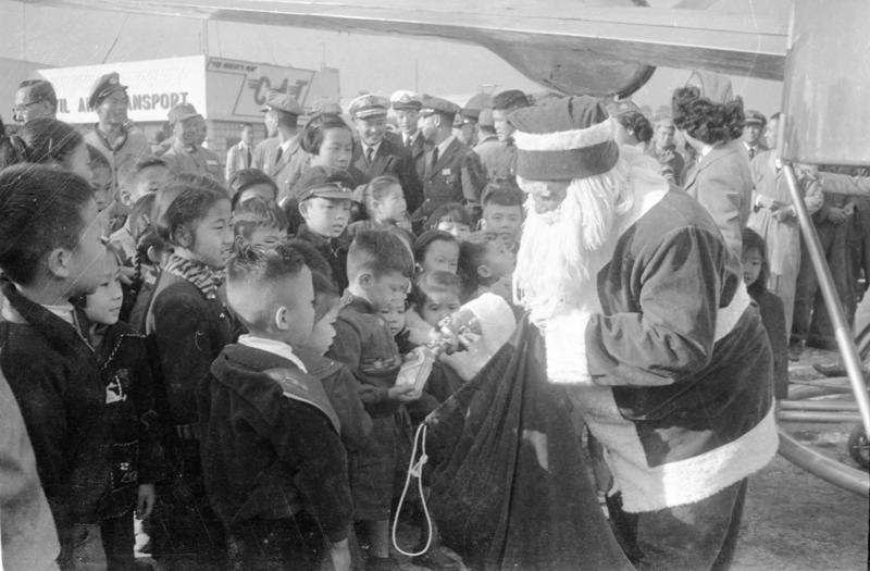 1955年12月25日，民航空運公司慶祝耶誕節，由該公司輸業務處長扮演「耶誕老人」，在機場分贈在場的十名兒童禮物。圖／聯合報系資料照片