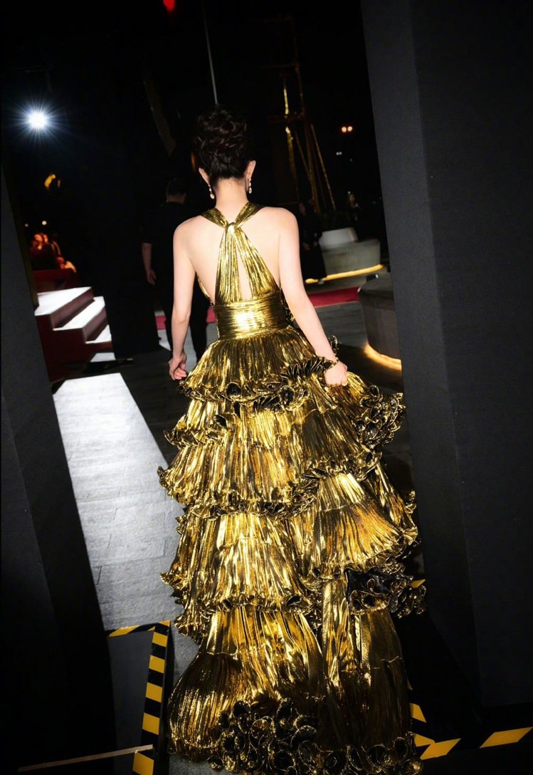楊冪穿上一襲金色蛋糕裙擺禮服出席活動，卻被吐槽像「行走的金色耶誕樹」。圖／摘自微博