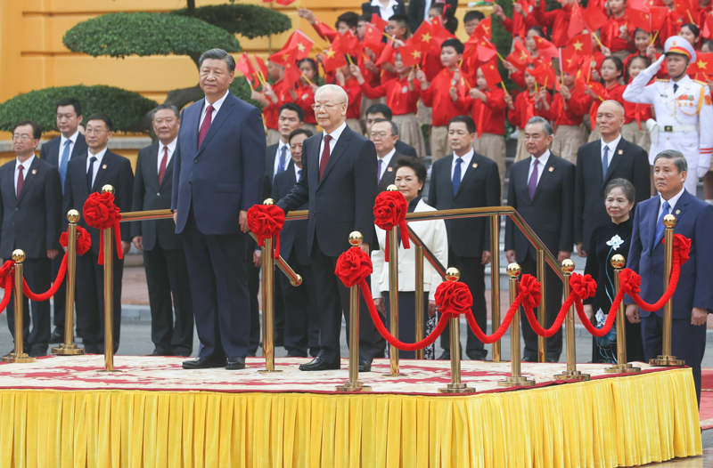 越共中央總書記阮富仲（前右）12月12日為對越南進行國是訪問的中國國家主席習近平（前左）舉行歡迎儀式。中新社