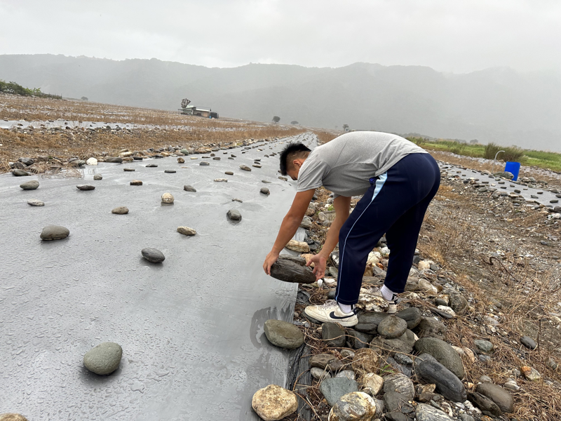 為西瓜產季預備，小安才有機會打工。一整天要彎腰搬石頭，還有要作各種整理、搬運的體力活。圖/台灣世界展望會提供