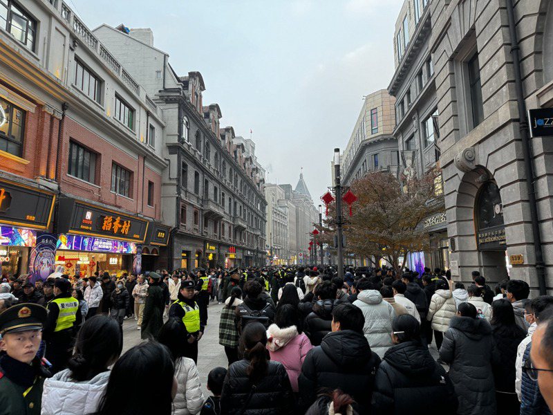31日上海南京路步行街人潮太多，警察與武警出動維持秩序，除了沿路廣播提醒注意事項外，並以人牆將不同方向的民眾區隔。中央社