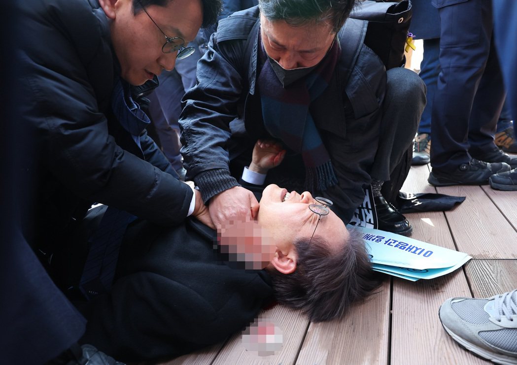 遇襲後李在明倒地，身邊的人以紗布壓住他脖子上的傷口。 圖／歐新社