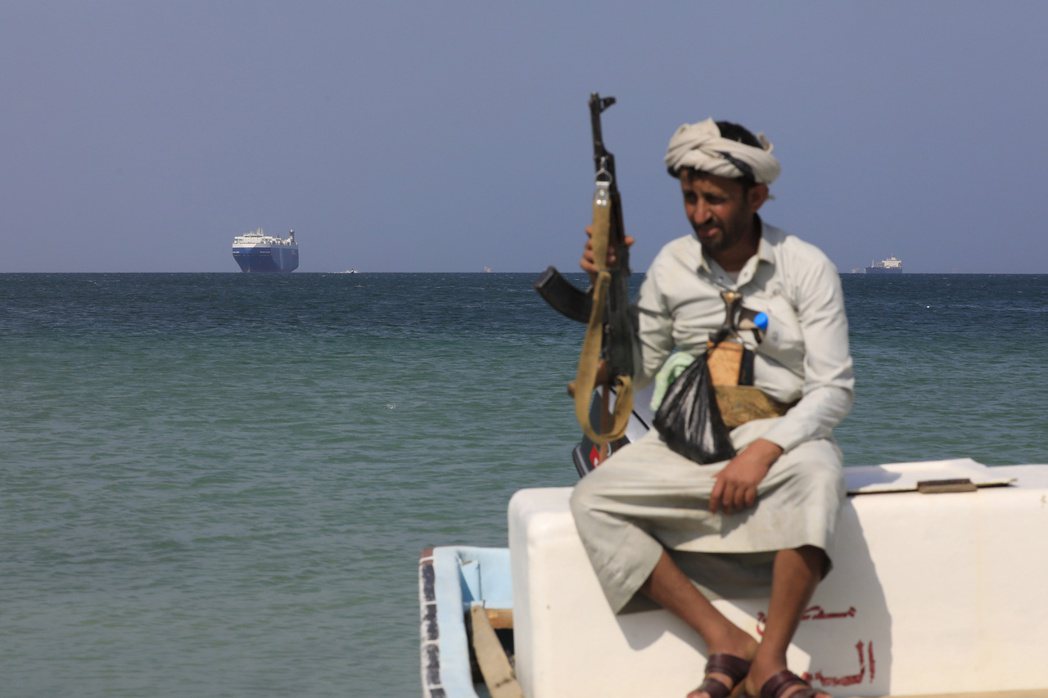 葉門武裝組織胡塞軍持續攻擊通過紅海的商船。圖為一名胡塞武裝人員坐在小船上，後方為...