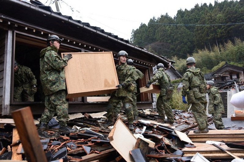 日本自衛隊士兵在石川縣珠洲地震後倒塌的房屋中進行救援。 圖／路透