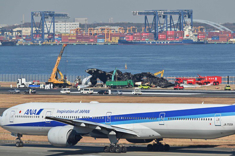 本月2日，日航一架客機與日本海上保安廳的飛機擦撞釀成重大意外。圖為事發後相關人員正在機場跑道上清除日航班機的殘骸。法新社