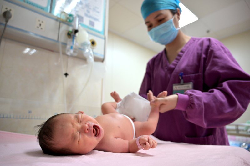 大陸各地官方近期紛紛將醫保報銷擴大到體外受精等輔助生育的項目。圖為助產士為新生兒進行體格檢查。（中新社）