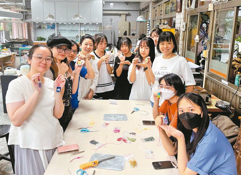 印尼籍台藝大學生李晶翠與鶯歌工商學生一同製作玻璃琺瑯御守。圖／新北教育局提供