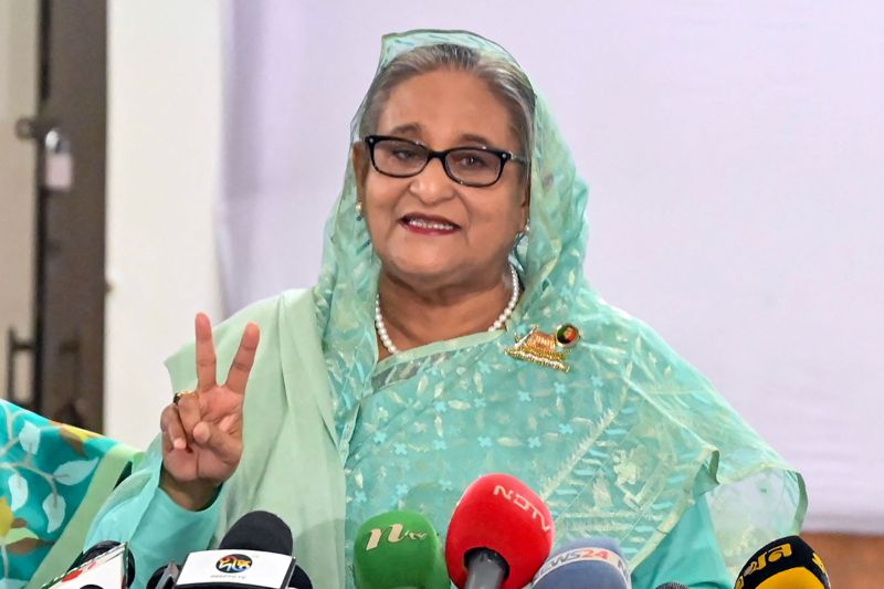 孟加拉總理哈希納在首都達卡投下國會大選選票後對媒體比出勝利手勢。法新社