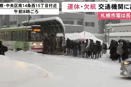 受大雪影響，許多前往札幌新千歲機場機場搭機的旅客，只能大排長龍在雪中苦等巴士。 截自影片