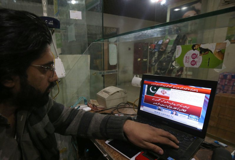 一名巴基斯坦男子正在觀看當地新聞台報導遭伊朗轟炸的消息。（歐新社）