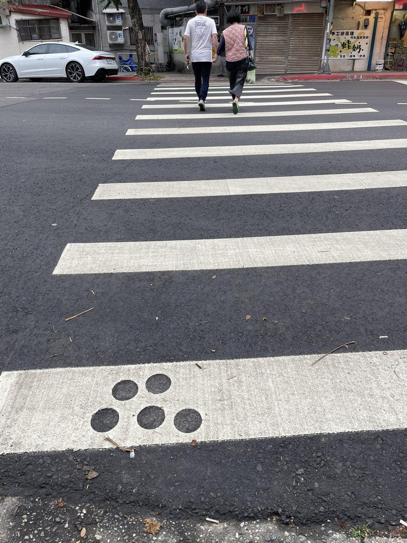 Mystery of Five Small Holes on Zebra Crossing Uncovered: Pedestrian Safety or Construction Oversight?